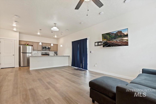 2312 E Spice Loop Unit 3, Nampa, ID 83687 - living area with light wood-style flooring, baseboards, a ceiling fan, and a textured ceiling