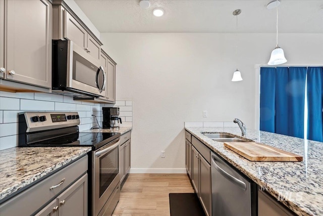 2312 E Spice Loop Unit 3, Nampa, ID 83687 - kitchen with stainless steel appliances, a sink, gray cabinetry, tasteful backsplash, and baseboards