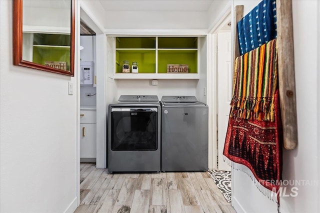 laundry area with washer and clothes dryer and light hardwood / wood-style floors