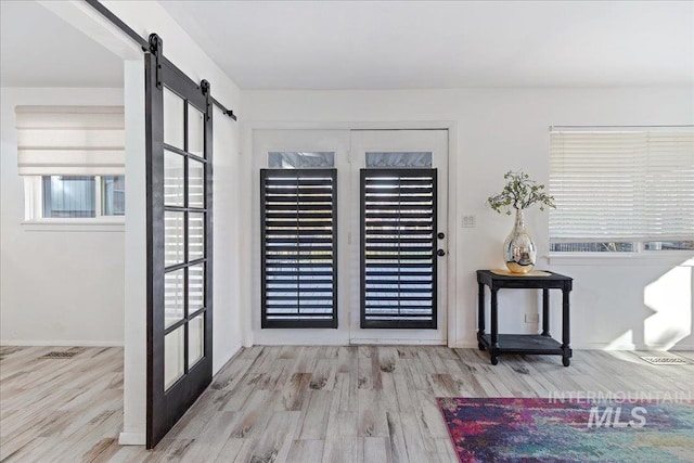 entrance foyer featuring a barn door and light wood-type flooring