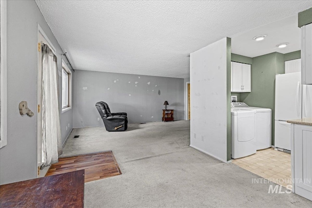 1267 NW Beaman St, Mountain Home, ID 83647 - laundry area featuring cabinet space, washing machine and dryer, light carpet, and a textured ceiling