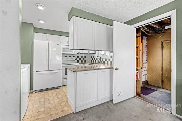 1267 NW Beaman St, Mountain Home, ID 83647 - kitchen featuring white appliances, a sink, white cabinetry, washer and dryer, and backsplash