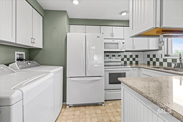 1267 NW Beaman St, Mountain Home, ID 83647 - kitchen with white appliances, a sink, independent washer and dryer, tasteful backsplash, and white cabinetry