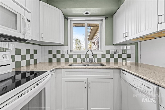 1267 NW Beaman St, Mountain Home, ID 83647 - kitchen featuring white appliances, a sink, white cabinets, tasteful backsplash, and light stone counters
