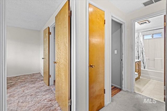 1267 NW Beaman St, Mountain Home, ID 83647 - corridor with carpet flooring, a textured ceiling, and baseboards