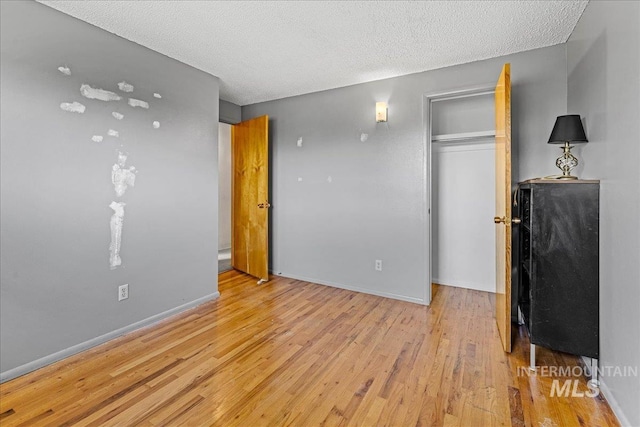 1267 NW Beaman St, Mountain Home, ID 83647 - unfurnished bedroom featuring light wood-type flooring, a textured ceiling, a closet, and baseboards