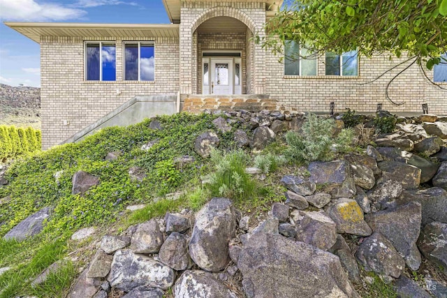 view of exterior entry featuring brick siding