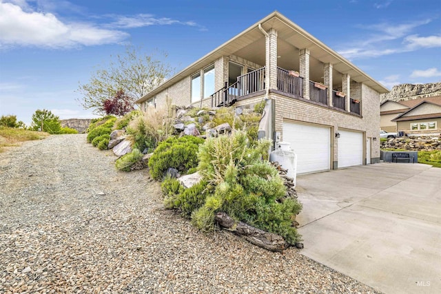 view of property exterior featuring brick siding, concrete driveway, and an attached garage