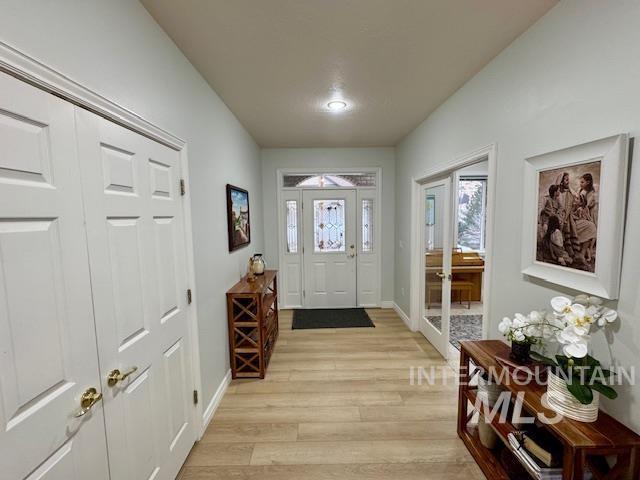 entryway featuring baseboards and light wood-style flooring