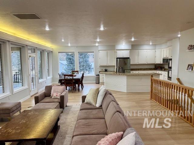 living area with light wood-style flooring, recessed lighting, baseboards, and visible vents