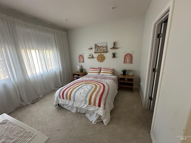 bedroom with light colored carpet and baseboards