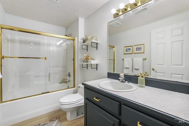 full bath with vanity, wood finished floors, visible vents, toilet, and combined bath / shower with glass door