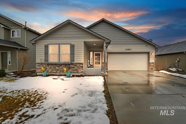 craftsman-style home featuring a garage, stone siding, and driveway