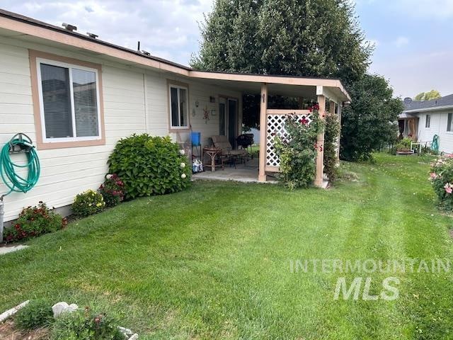 back of property featuring a patio and a lawn