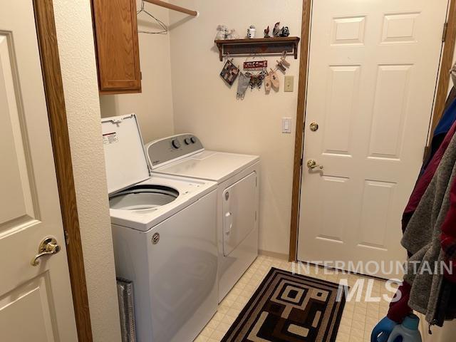 1100 Burnett Dr Unit 348, Nampa, ID 83651 - laundry area featuring cabinet space, baseboards, washer and clothes dryer, and light floors
