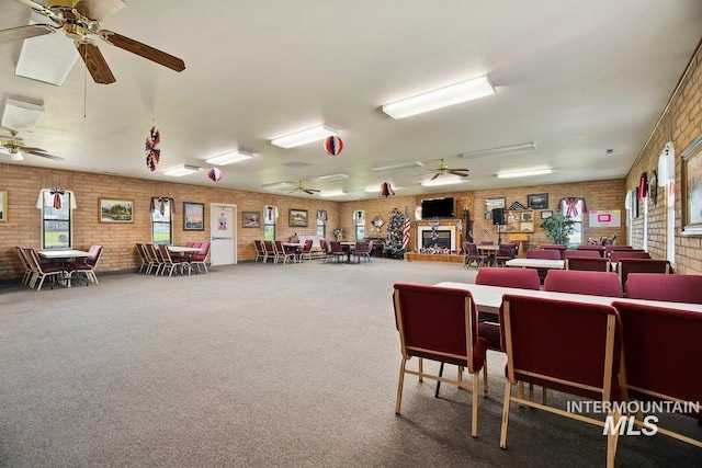 interior space with ceiling fan and brick wall