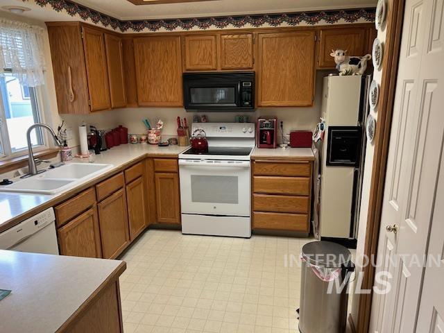 1100 Burnett Dr Unit 348, Nampa, ID 83651 - kitchen with light countertops, white appliances, a sink, and brown cabinets
