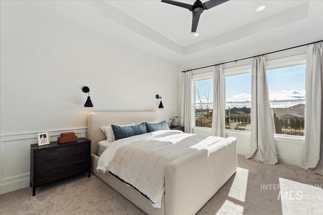 bedroom featuring light carpet, a raised ceiling, ceiling fan, and recessed lighting