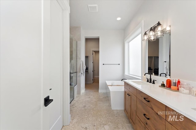full bathroom featuring a bathtub, a stall shower, vanity, and baseboards
