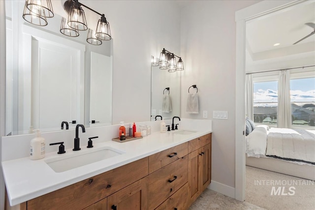 ensuite bathroom with double vanity and baseboards