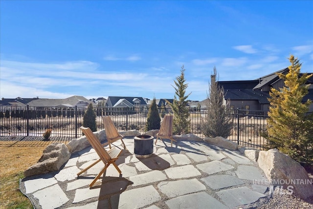 view of patio / terrace featuring an outdoor fire pit, a residential view, and fence