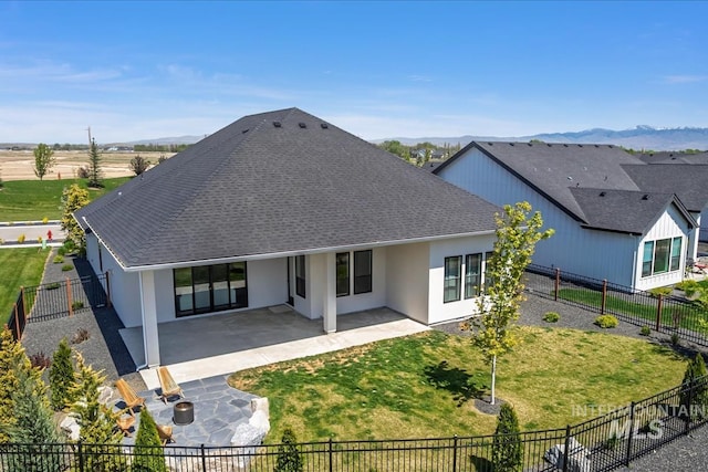rear view of property featuring a patio, roof with shingles, stucco siding, and a mountain view