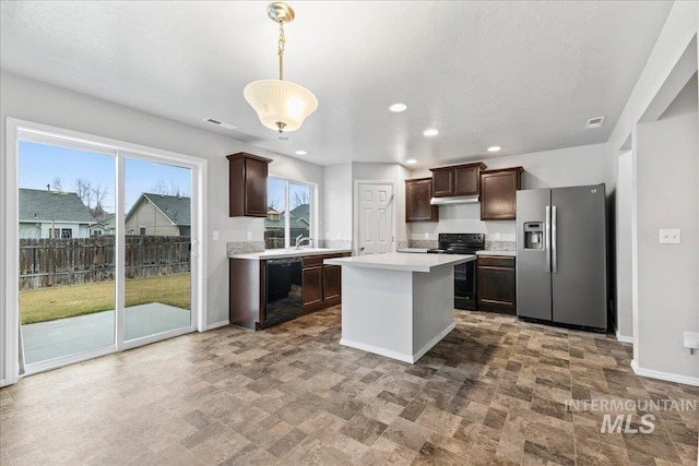 kitchen with light countertops, hanging light fixtures, dark brown cabinetry, black appliances, and baseboards