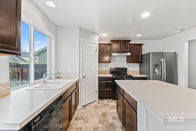 kitchen featuring decorative backsplash, under cabinet range hood, light countertops, black appliances, and a sink