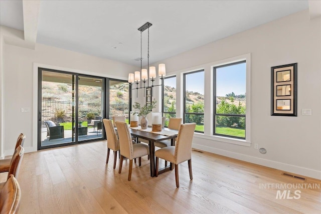 dining area featuring light hardwood / wood-style flooring and a chandelier