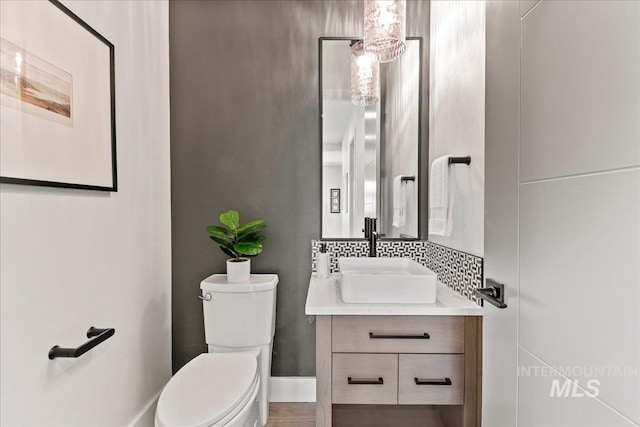 bathroom with vanity, toilet, and tasteful backsplash