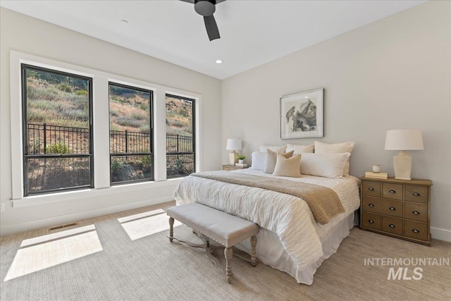 carpeted bedroom with multiple windows and ceiling fan