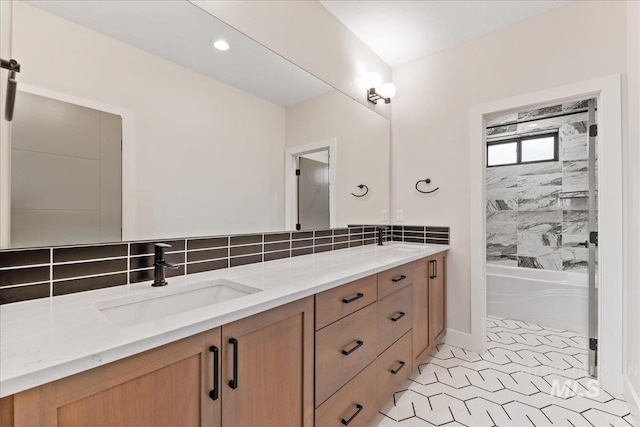 bathroom with tasteful backsplash, vanity, and tiled shower / bath