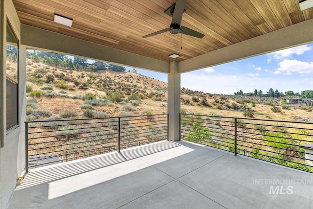 view of patio featuring ceiling fan and a balcony