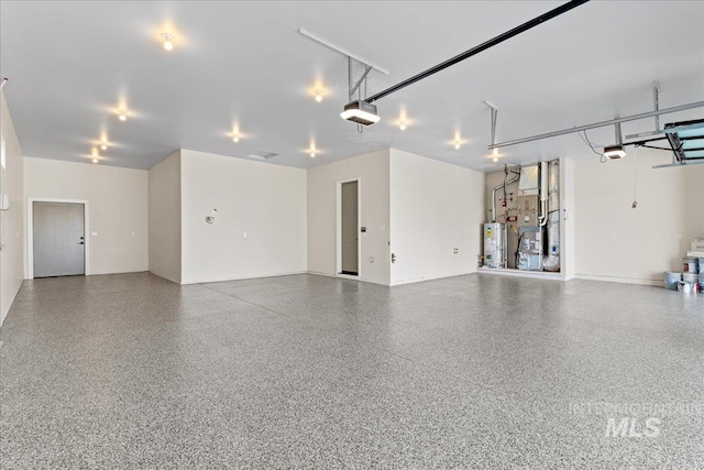 garage featuring heating unit, a garage door opener, and water heater