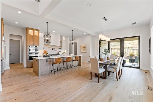 dining area featuring sink and light wood-type flooring