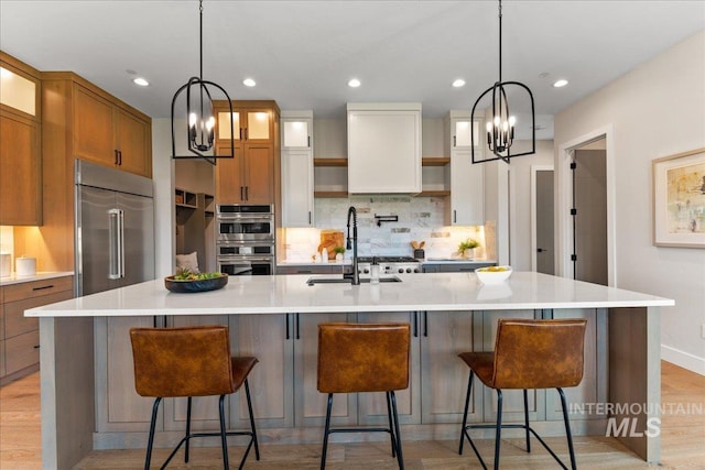 kitchen featuring a notable chandelier, a large island with sink, and appliances with stainless steel finishes