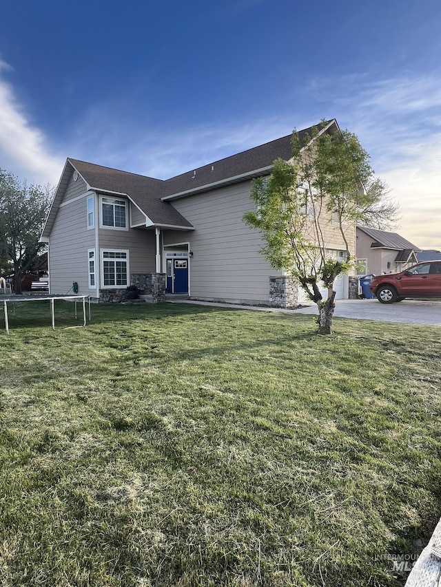 140 W Valley Rd, Hagerman, ID 83332 - view of front of property featuring driveway, a front lawn, stone siding, and a garage