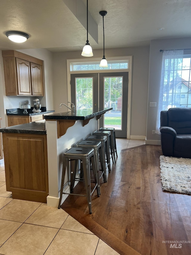 140 W Valley Rd, Hagerman, ID 83332 - kitchen featuring a breakfast bar, baseboards, decorative light fixtures, an island with sink, and a textured ceiling