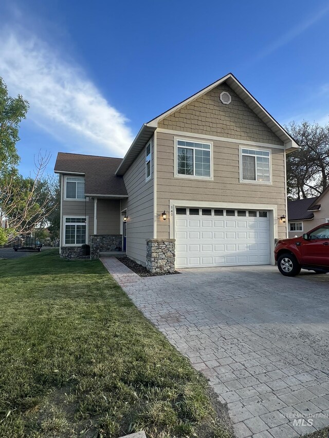 140 W Valley Rd, Hagerman, ID 83332 - view of front of house featuring an attached garage, decorative driveway, stone siding, and a front yard
