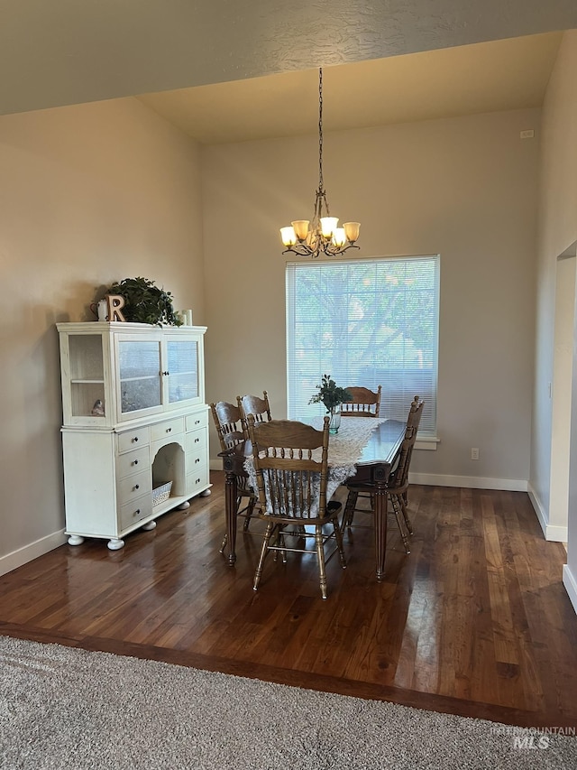 140 W Valley Rd, Hagerman, ID 83332 - dining area featuring a chandelier, dark wood-style floors, baseboards, and vaulted ceiling