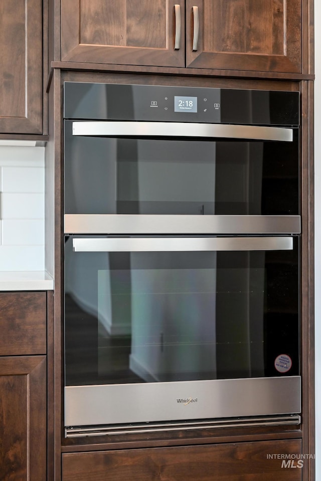 details with dark brown cabinets and stainless steel double oven