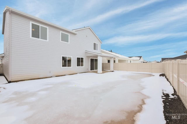 view of snow covered back of property