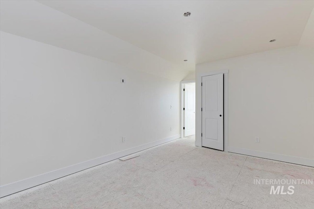 unfurnished room featuring vaulted ceiling