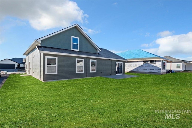 rear view of house featuring a yard