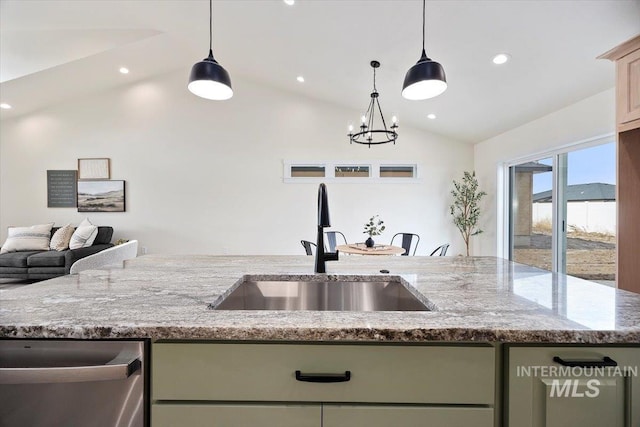 kitchen with lofted ceiling, sink, hanging light fixtures, light stone countertops, and green cabinetry