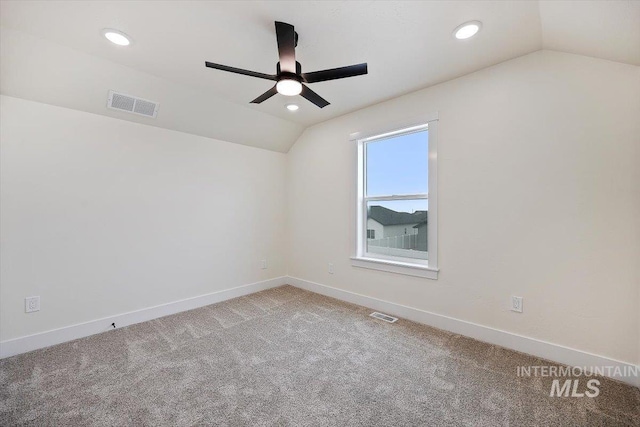 carpeted spare room featuring lofted ceiling and ceiling fan