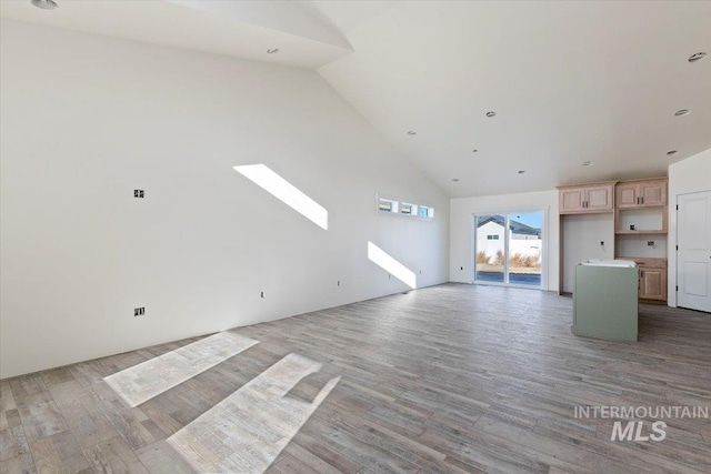 unfurnished living room with hardwood / wood-style flooring and high vaulted ceiling