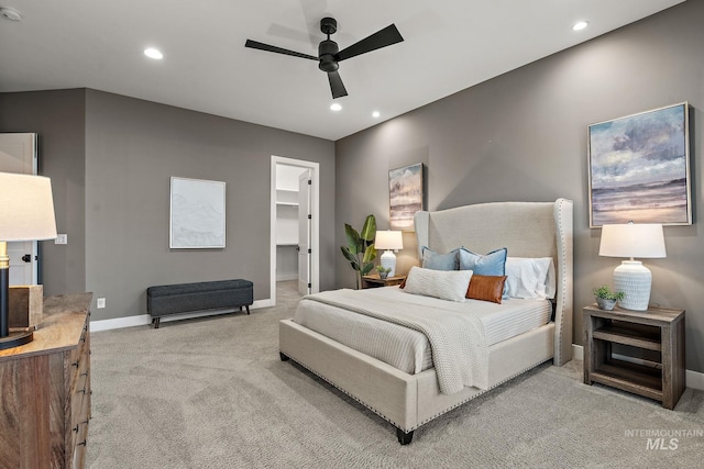 carpeted bedroom featuring ceiling fan, a walk in closet, and a closet