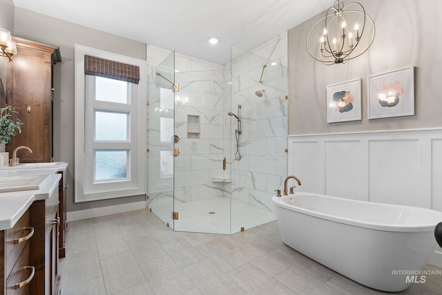bathroom featuring a notable chandelier, vanity, and shower with separate bathtub
