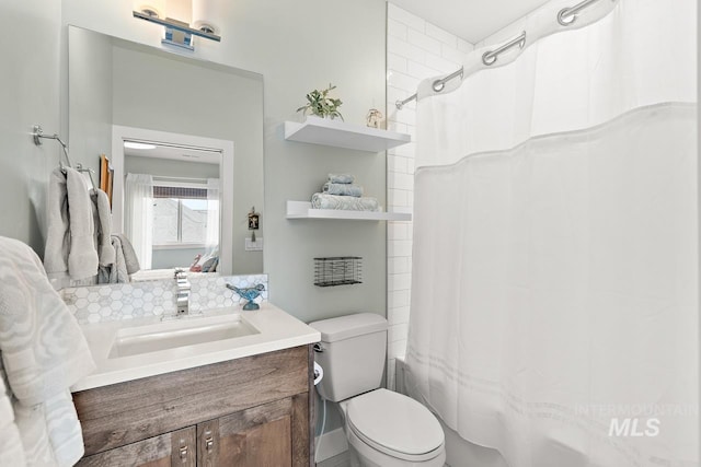 full bathroom featuring shower / tub combo with curtain, vanity, and toilet